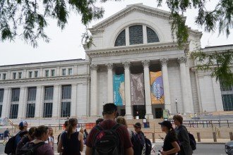 A crowd stands in front of the National Museum of Natural History.