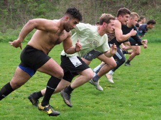 Rugby players line up to run a sprint.