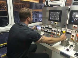 Ganzak sits at the controls of a NASA crane.
