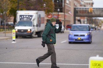 Dr. Ron Van Houten crosses a road in a crosswalk.