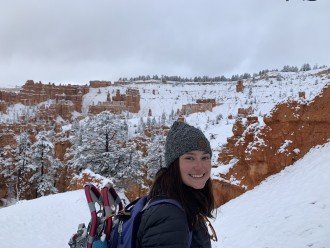 Raegan Delmonico poses on a snowy mountain during a hike.