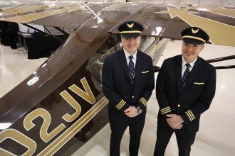 Pilots Josh and Tim Carpenter stand next to a plane.