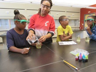 A graduate student does a chemistry experiment with kids.