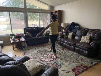 Jolin Cramer dances in her living room in front of her laptop where class is going on.