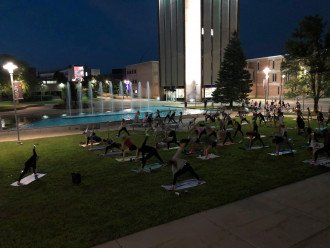 Dozens of students participate in yoga at night.