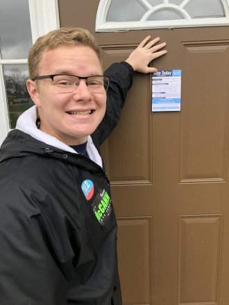 Michael Sekich posts a note on a door.