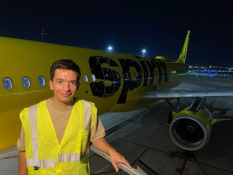 Luis Jaime stands next to a Spirit Airlines plane.