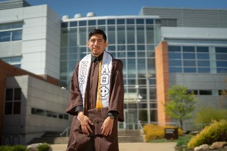 Jovanny Ruiz-Alavez poses in his graduation regalia.