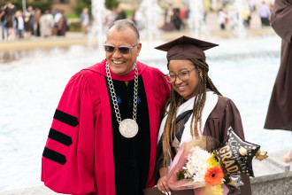 President Montgomery poses for a picture with a graduate.