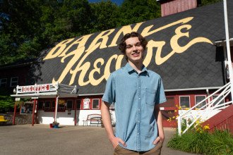 Jack Austin stands in front of the Barn Theatre building.