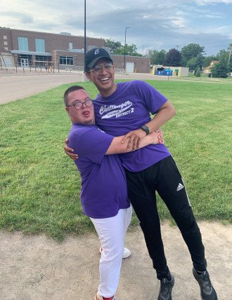 A photo of Luis Morales hugging a Challenger Little League player.