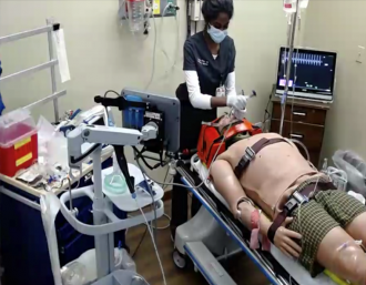 A doctor works on a mannequin in an emergency medicine simulation lab.