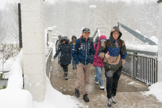 Students walk through the snow outside.