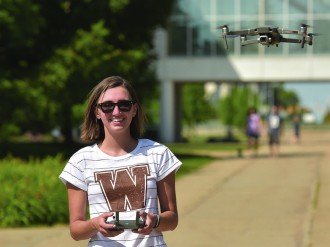 Claire flying drone on campus