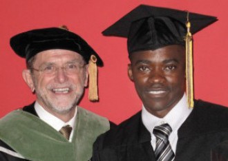 Student and University President in graduation regalia.