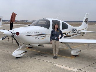 Ashley Pratt standing next to one of Western's Cirrus SR20 aircraft.