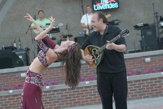 Photo of a band performing with a belly dancer.