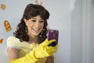 A student dressed as a princess smiles on a FaceTime call.