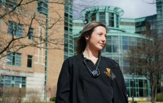A nursing student stands outside with her stethoscope around her neck.