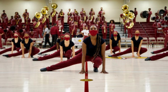 Shaniya Tate performing with a dance team in a gymnasium.