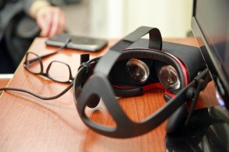 Photo of close up of virtual reality goggles, glasses and a computer.