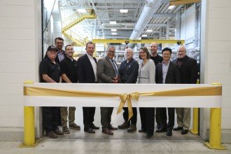 Photo of WMU President Edward Montgomery, WMU Pilot Plants staff and paper industry representatives standing in front of a gold ribbon inside the facility.