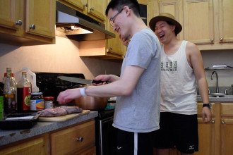 Left to right, students Joseph Yang and Po-Hsien “Johnny” Chen cook Taiwanese beef noodles by a stove.