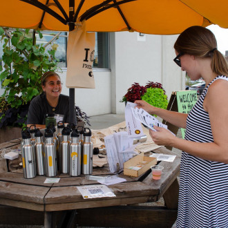  Student passing out EcoEssentials at annual Sustainability Celebration
