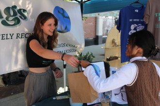 Siera Gunnett hands a bag to a customer at her SheMakings tent