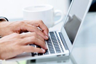 Stock photo of hands typing on a laptop
