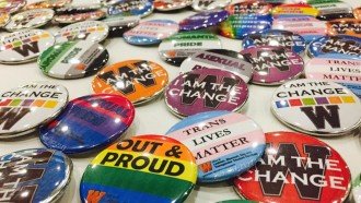 Multiple buttons that display positive LGBT messages such as: Out and Proud, Trans Lives Matter, I am the Change.