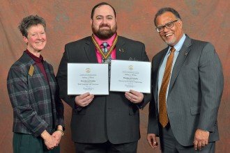 Joshua White displays his two Presidential Scholar certificates flanked by the presidents of WMU and its Faculty Senate.