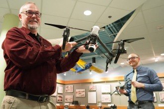 Emerson and Mathews holding examples of the drones at their disposal.