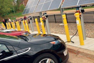 Cars lined up at a group of on-campus charging stations.