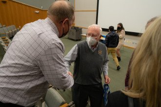Dr. Tom Carey shakes hands during his last lecture