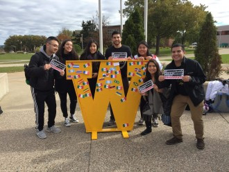 students with WMU sign "I stand with immigrants"
