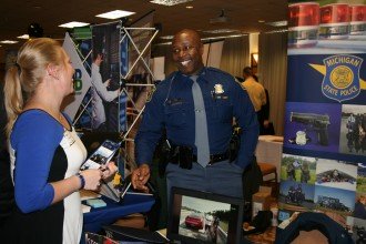 Student talking to a MI State Police Officer at the career fair