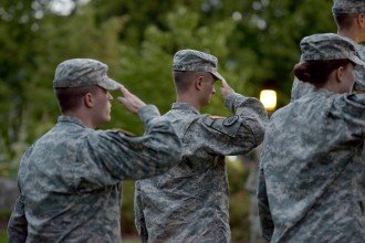 Three WMU Army ROTC cadets saluting a far-off flag.