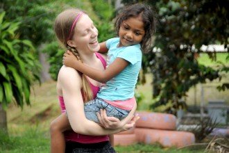 Photo of Kelci Winchell posing with a child from the orphanage.