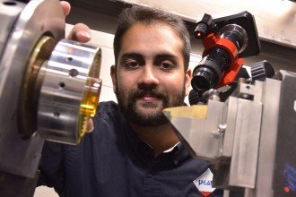 Photo of Dr. Deepak Ravindra looking inside a laser-assisted machining setup.