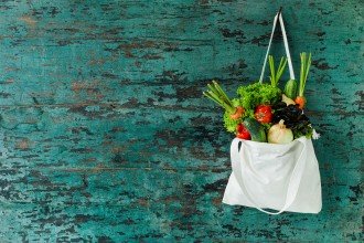 Photo of a fresh vegetables hanging in a natural cotton recyclable shopping bag.