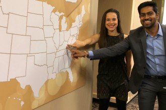 Two WMed students point to the state of Kentucky on a U.S. map during their Match Day event.