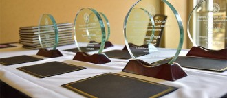 Glass and wooden WMU alumni achievement awards sit on a table.