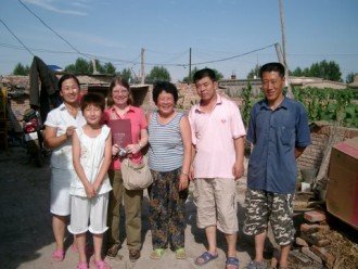 Photo of Dr. Ann Veeck with a family in China.