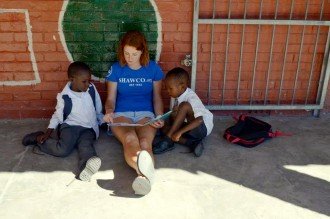 WMU student reading to African children.