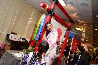 A Japanese exchange student smiles for the camera as the Japan Club prepares its display.