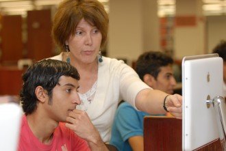 CELCIS instructor works with a student in computer lab