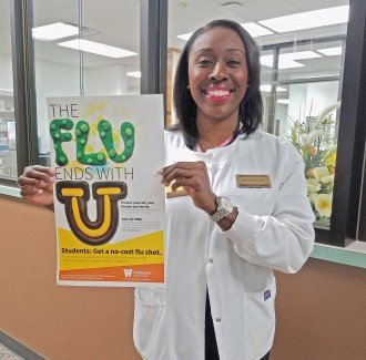 Nurse holding poster that says "the flu ends with you"