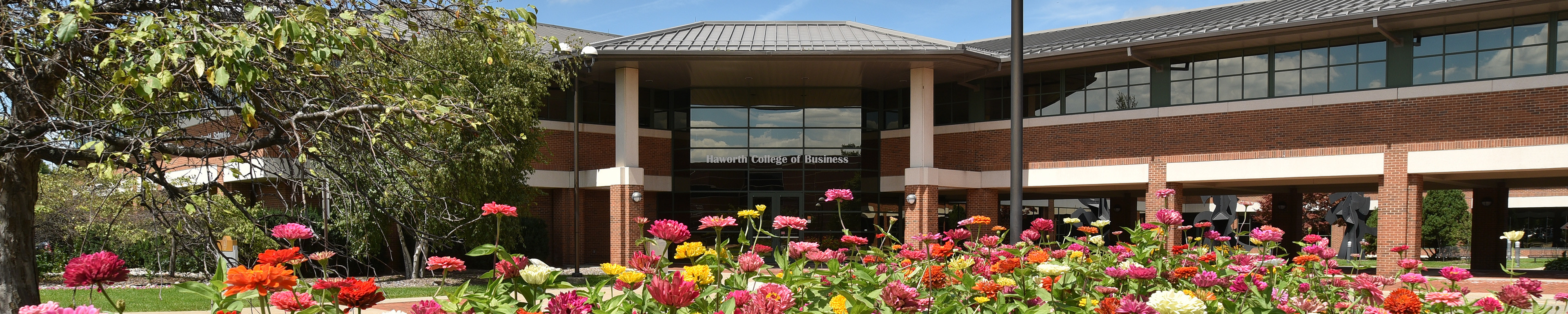 Flowers in bloom outside of the exterior of the Haworth College of Business. 