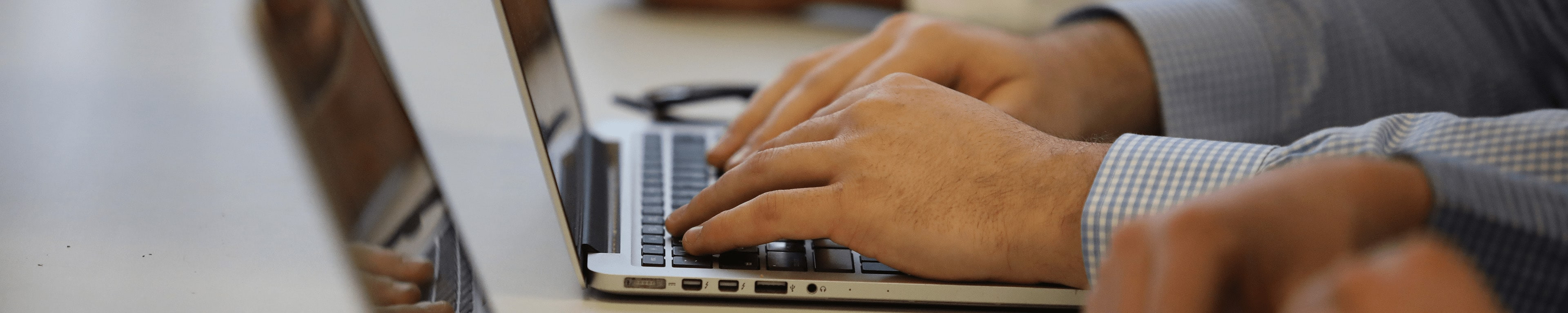Someone's hands typing on a laptop. 